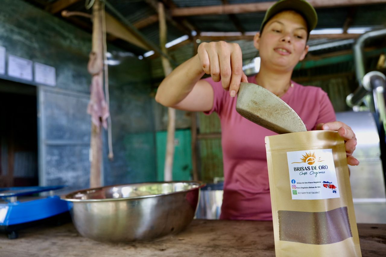 A woman is holding a bag of powder next to a bowl.