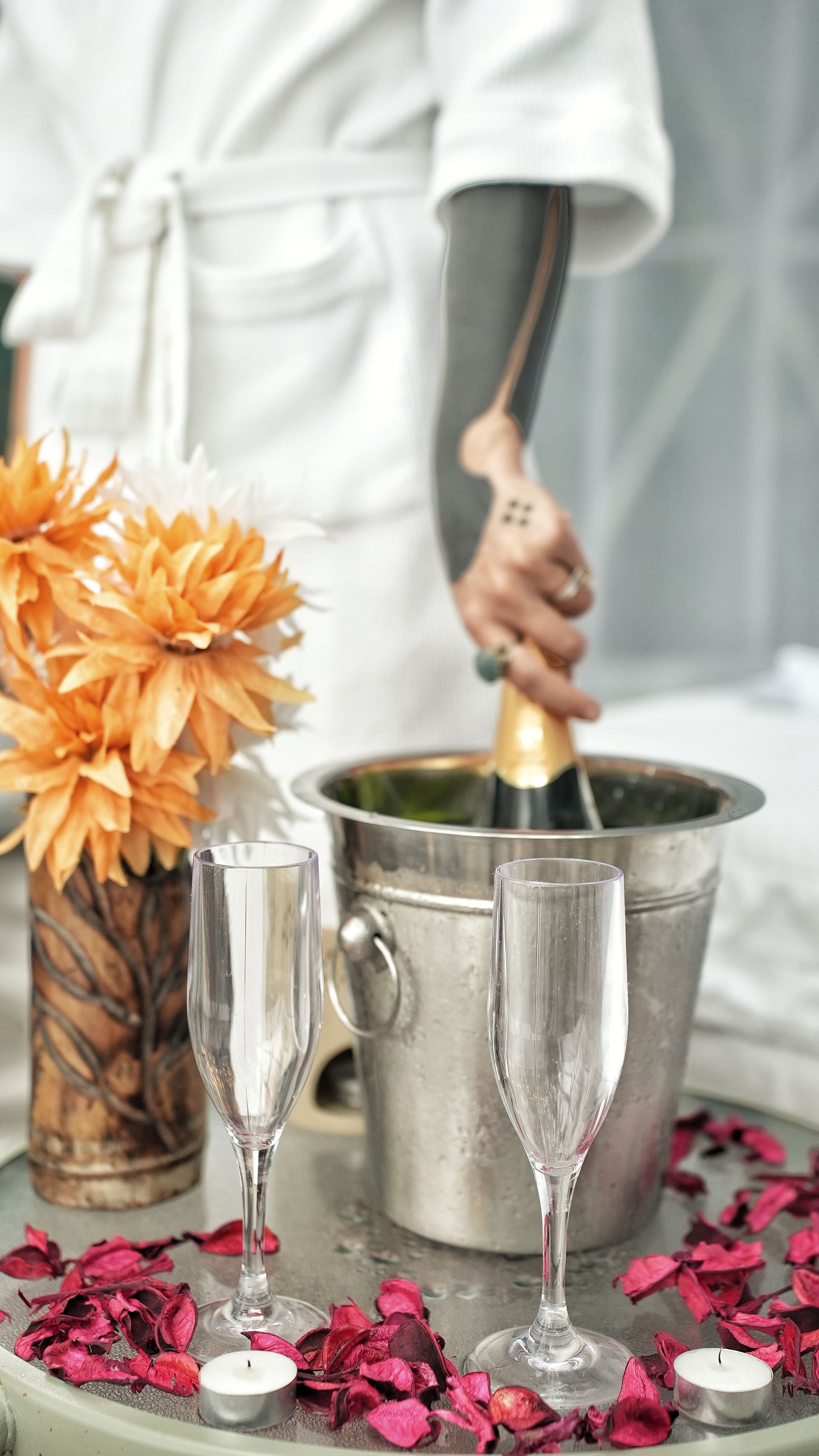 A woman is opening a bottle of champagne in a bucket.