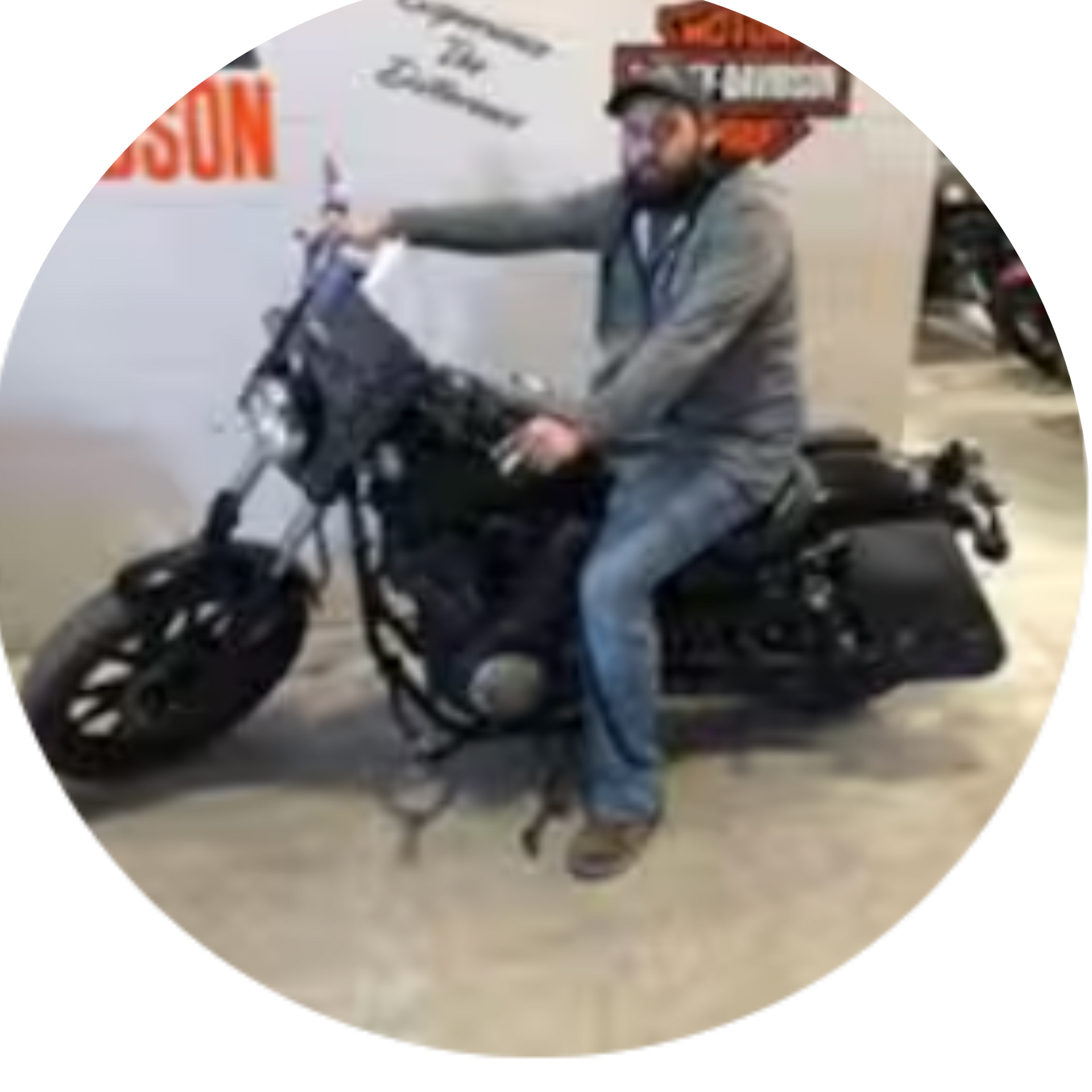 Man on a black motorcycle indoors at a Harley-Davidson dealership.