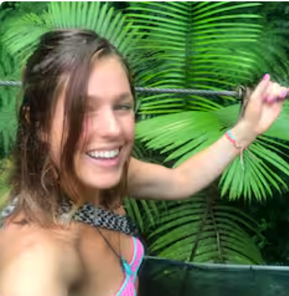 A woman in a bikini is taking a selfie in the jungle.