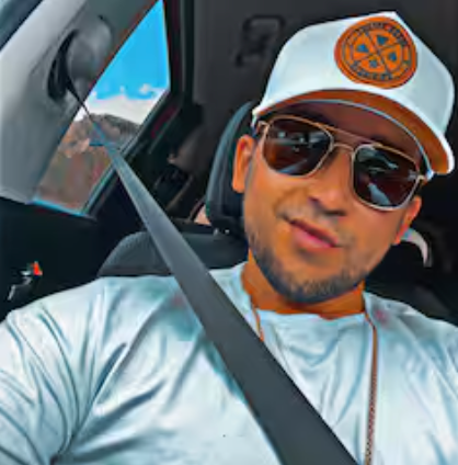 A man wearing a hat and sunglasses is sitting in a car.