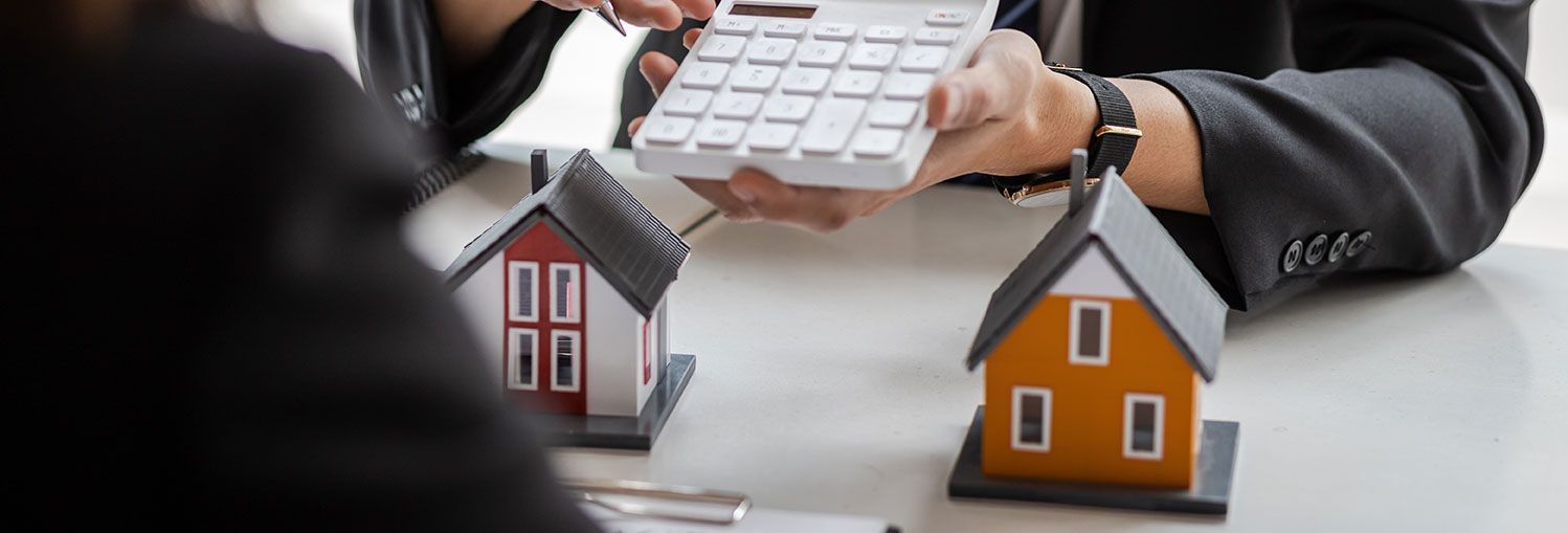 Agent immobilier qui donne un chiffre sur une calculette pour l'achat d'une maison