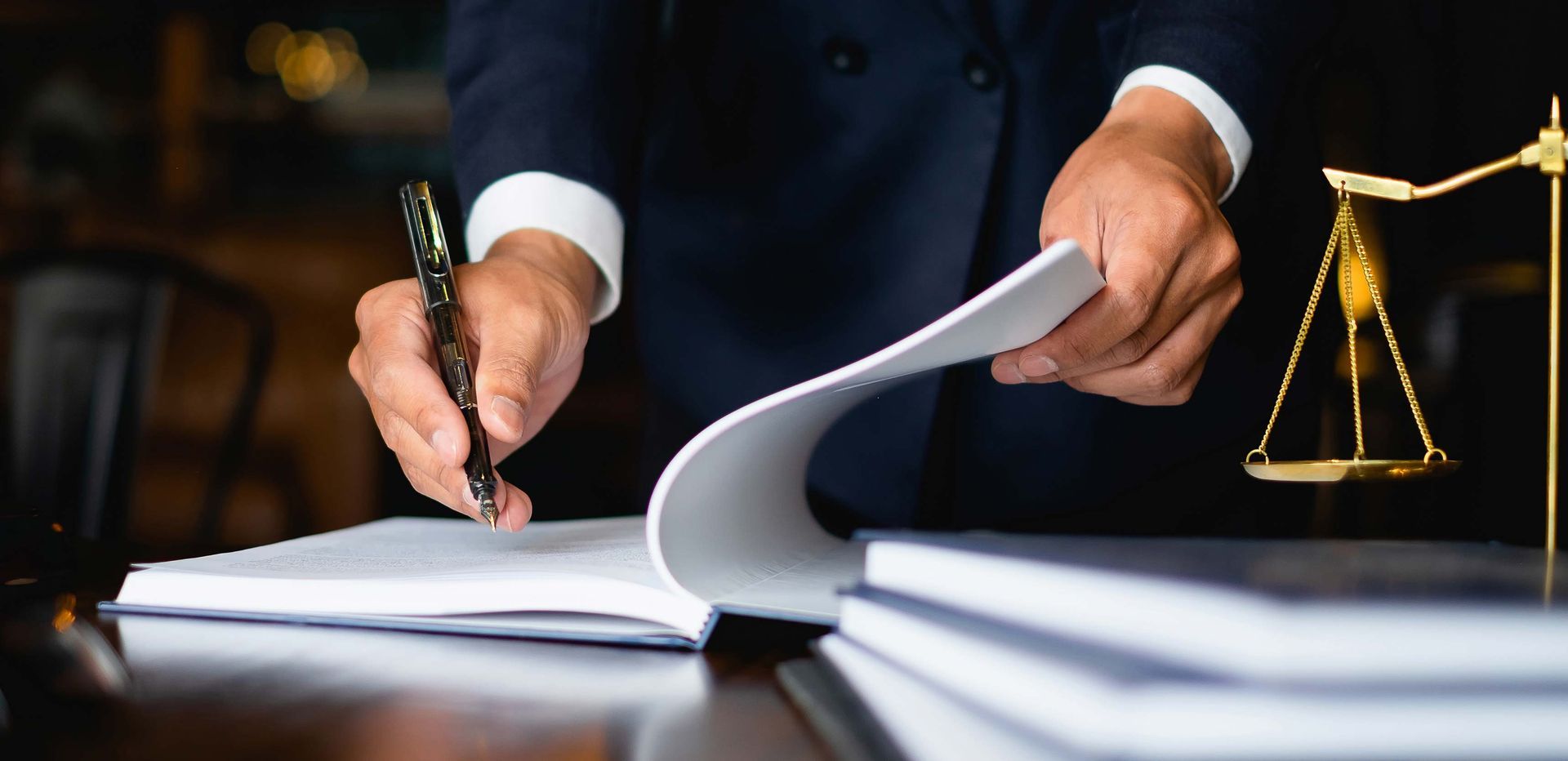 Avocat qui signe des documents sur son bureau