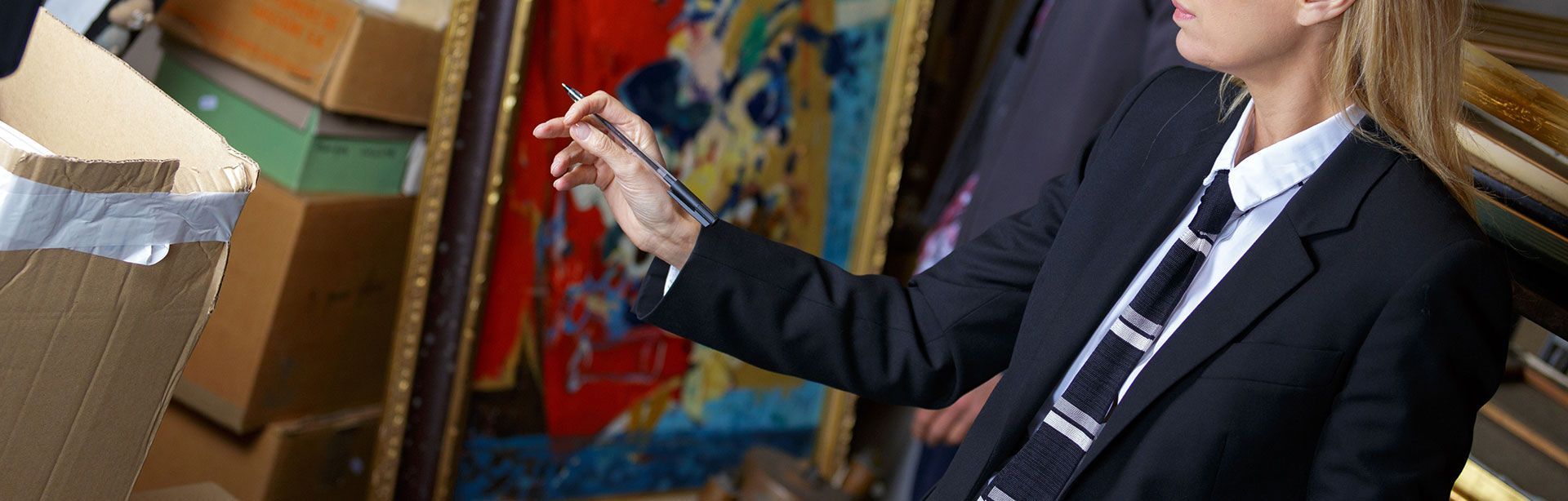 Femme commissaire-priseur qui estime la valeur d'un tableau