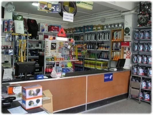 El interior de una tienda de repuestos para automóviles con estantes y un mostrador.