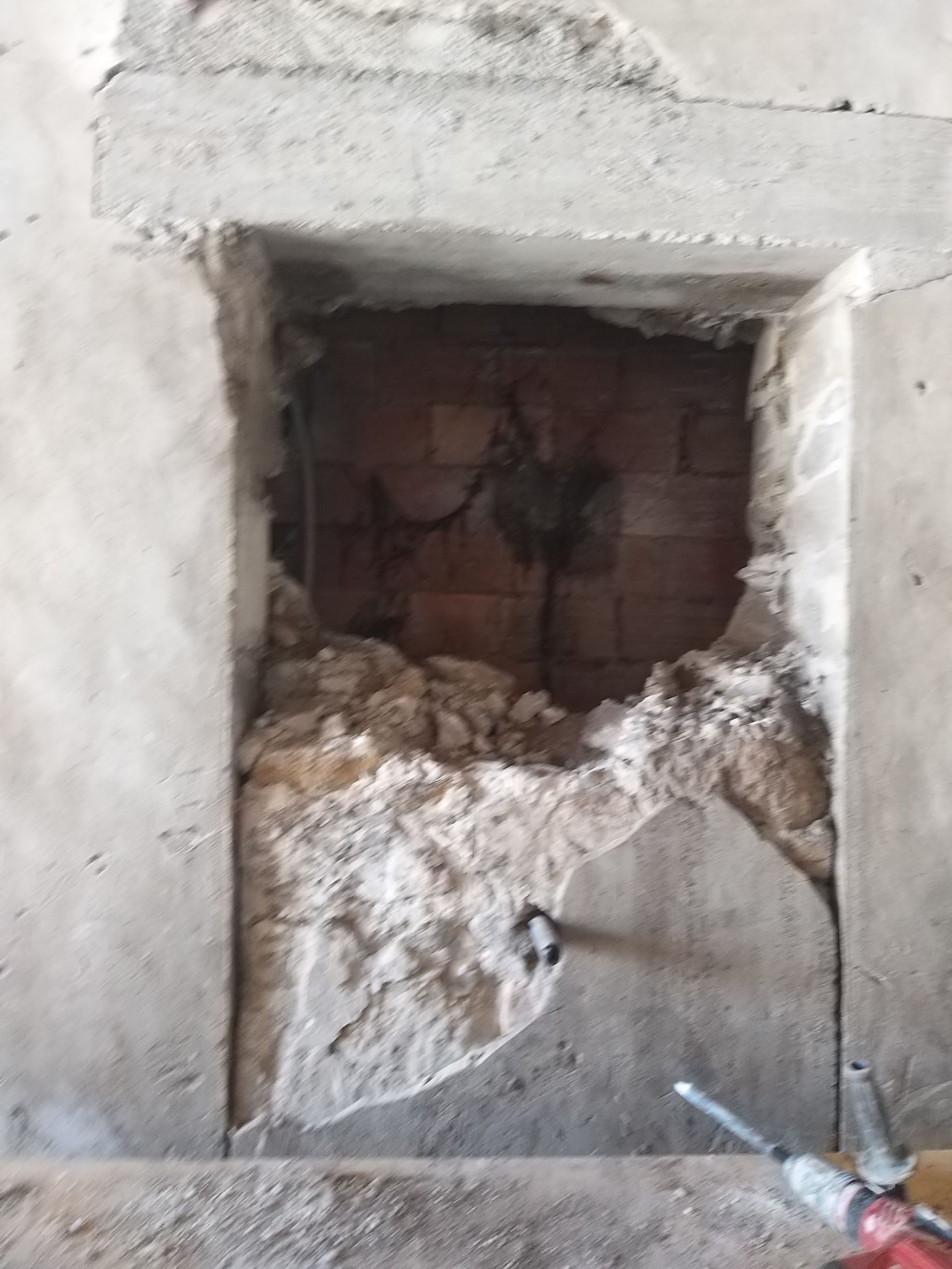 Ouverture d'une fenêtre dans un mur en béton et brique