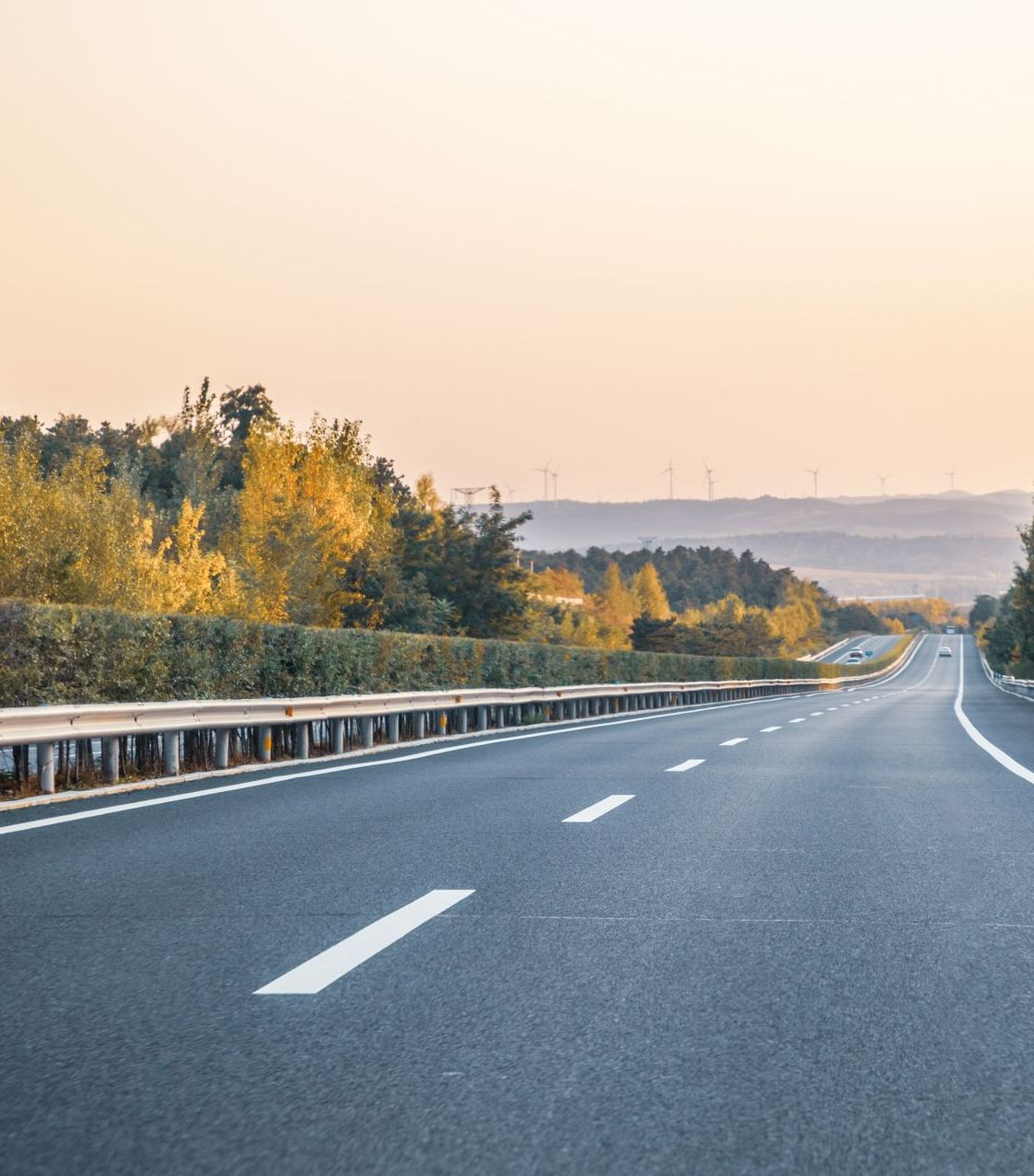 Une autoroute déserte s'étend vers l'horizon sous un ciel brumeux