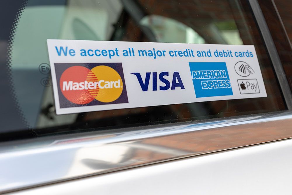 Ein Auto mit einem Stoßstangenaufkleber, auf dem steht, dass wir alle gängigen Kredit- und Debitkarten akzeptieren
