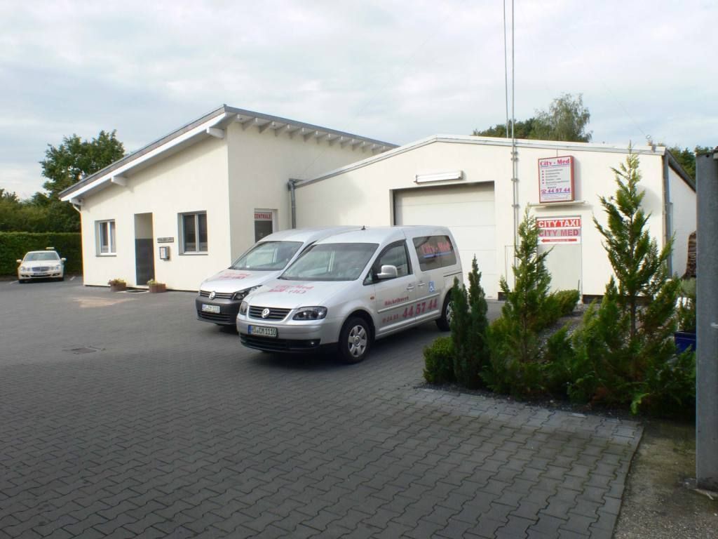 Zwei Lieferwagen stehen vor einem weißen Gebäude
