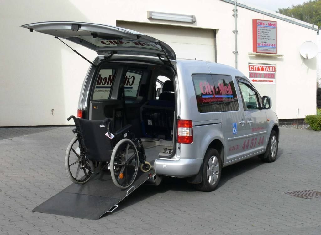 Ein silberner Van mit einem Rollstuhl auf der Ladefläche
