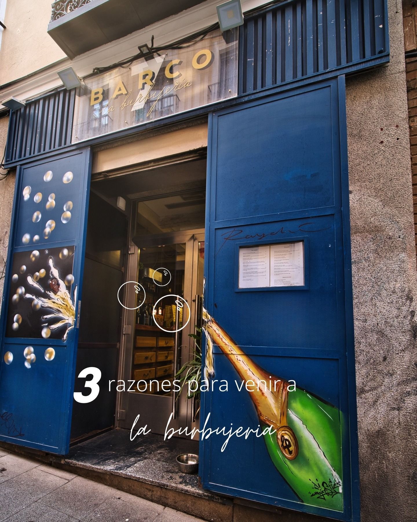 Fachada azul con puertas abiertas y un letrero que dice “MARCO”, con texto en español superpuesto en la parte inferior.
