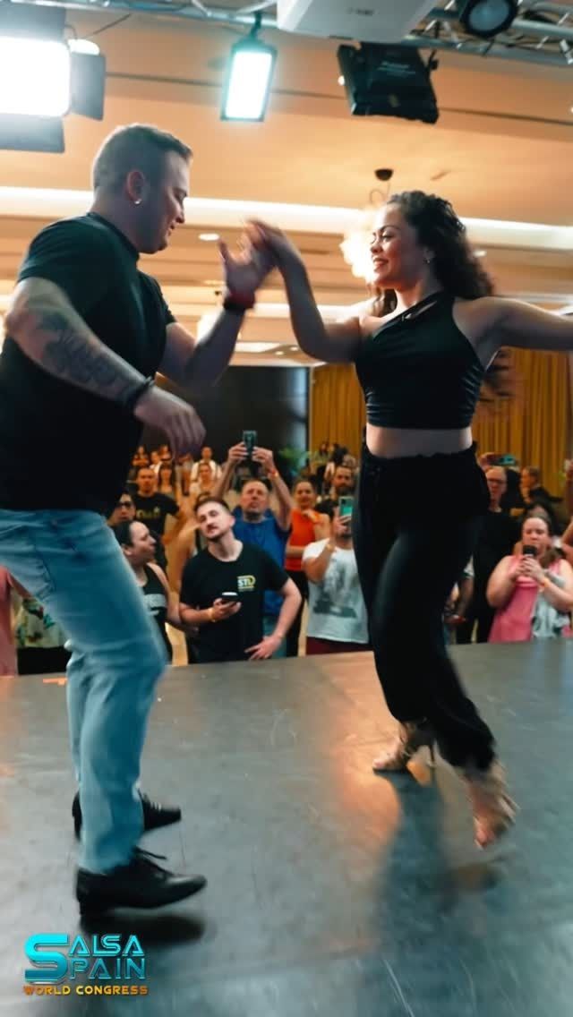 Un hombre y una mujer están bailando frente a una multitud.