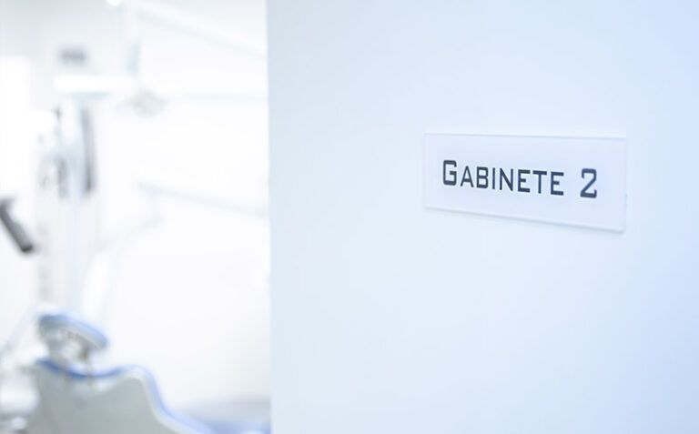 Pasillo blanco con un letrero en la puerta que dice "GABINETE 2" en una pared clara.