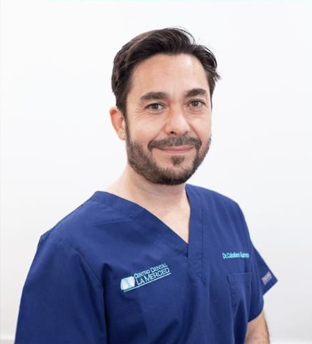 Profesional sanitario sonriente con uniforme azul sobre fondo blanco