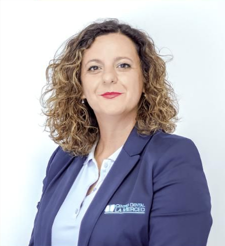 Mujer profesional con blazer azul sobre fondo blanco, mirando al frente y sonriendo levemente.