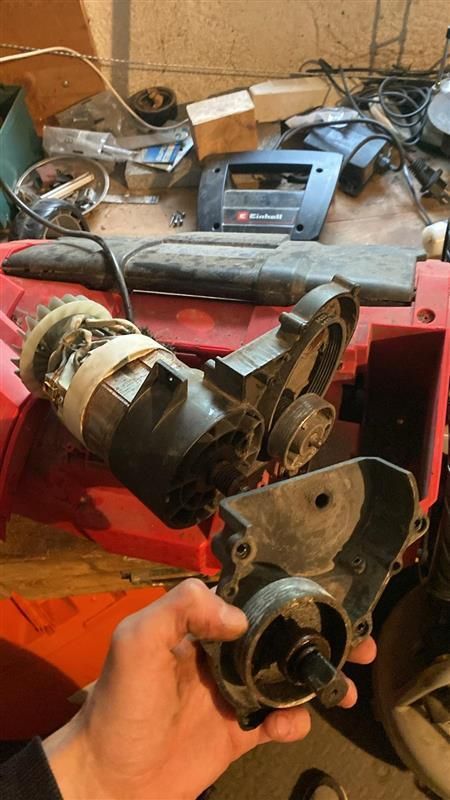 Une personne tient une pièce de machine dans sa main.