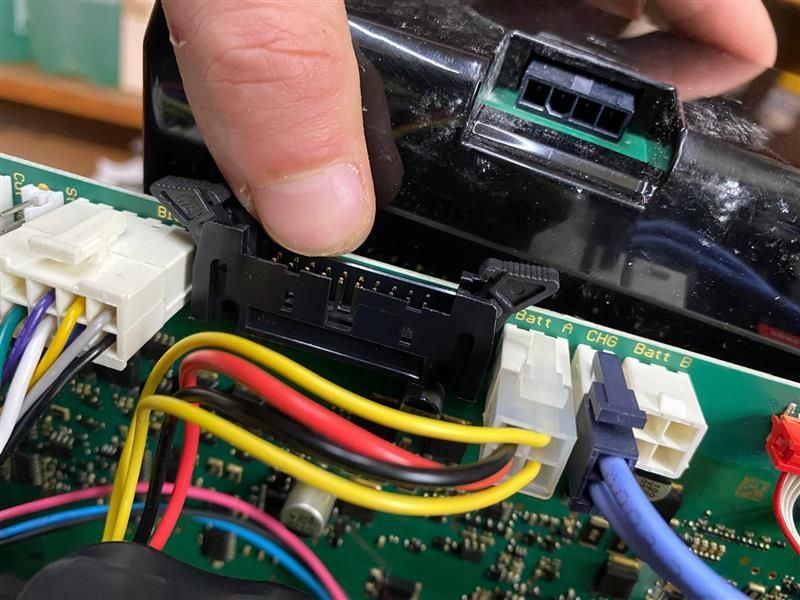 Une personne travaille sur une carte mère avec des fils et des connecteurs