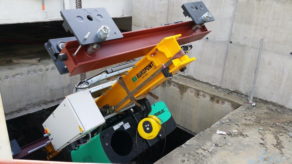 Des mains rabotent un bloc de bois sur un établi dans un atelier