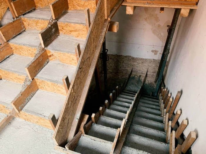 Unfertige, im Bau befindliche Innentreppe mit freiliegendem Holzgerüst und Betonstufen