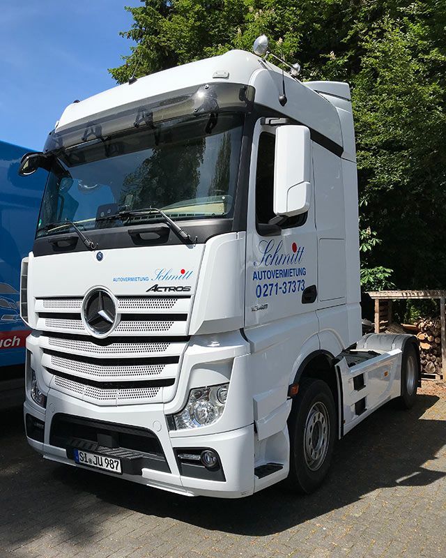 Ein weißer Mercedes-Truck steht auf einem Parkplatz.