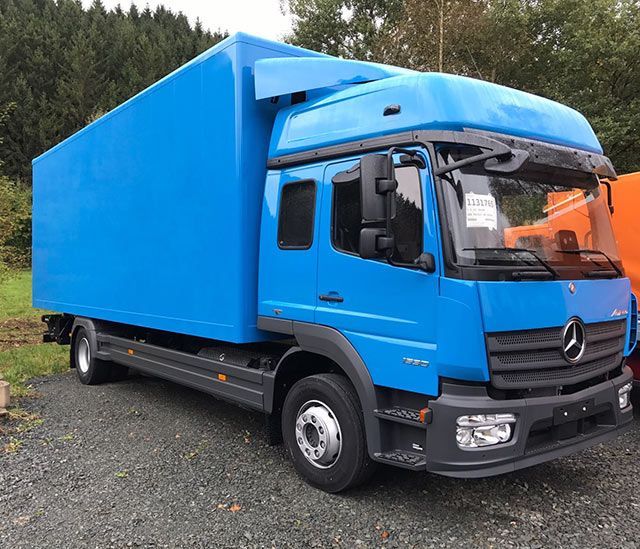 Ein blauer Mercedes-Truck steht auf einem Schotterplatz.