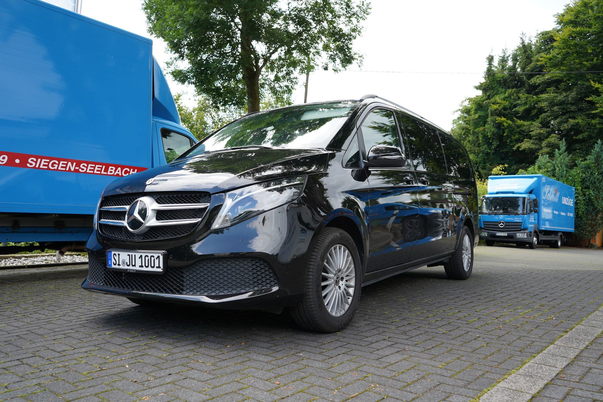 Ein Mercedes-Van steht vor einem Gebäude mit der Aufschrift „Autovermietung“