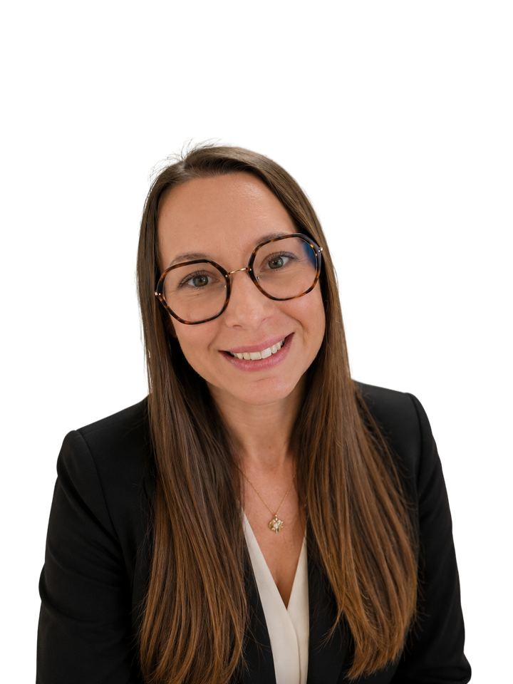 Femme souriante portant des lunettes et un blazer noir sur fond blanc