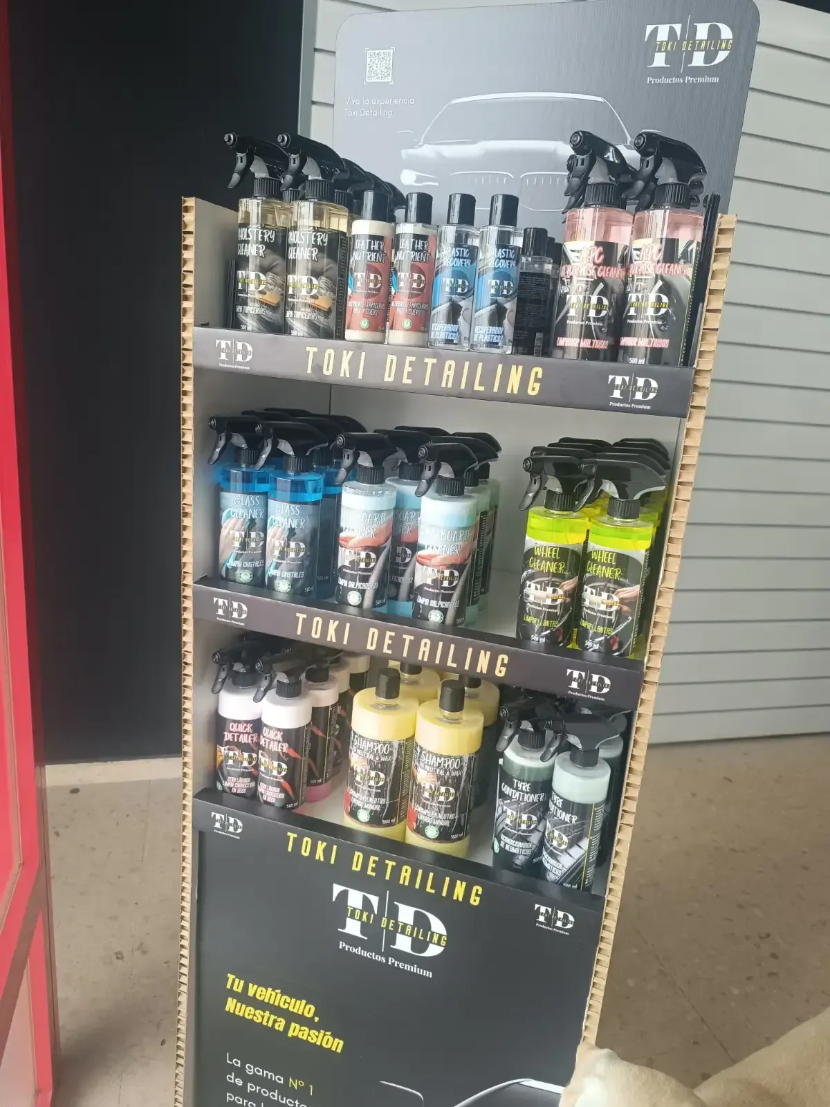 Interior de una tienda con botas sobre mesas. El local tiene techos altos, un mural y asientos.