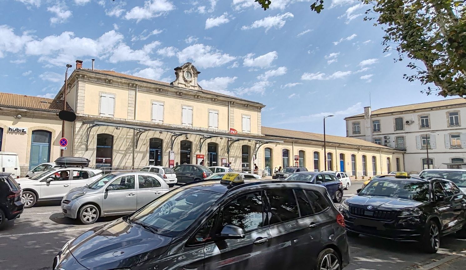 Femme descendant d'un véhicule haut de gamme à proximité d'une gare