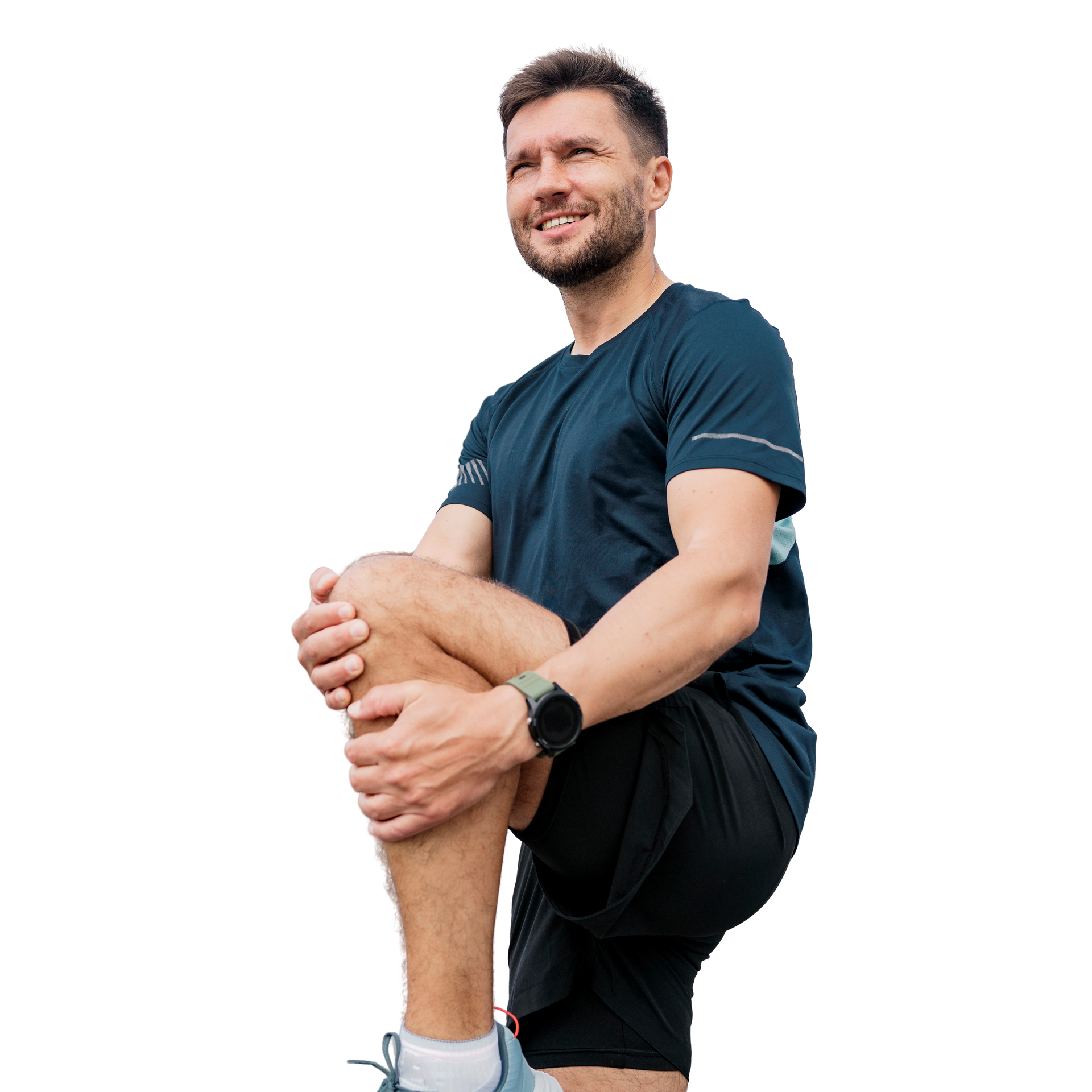 Un homme en tenue de sport, la jambe étirée, souriant, porte une montre.