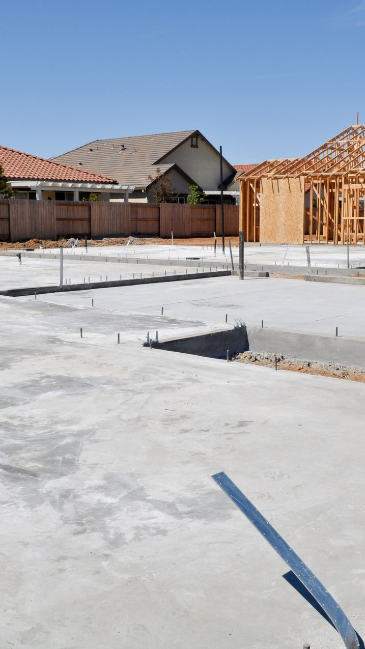 Fondations en béton armé, maison en construction, quartier résidentiel.