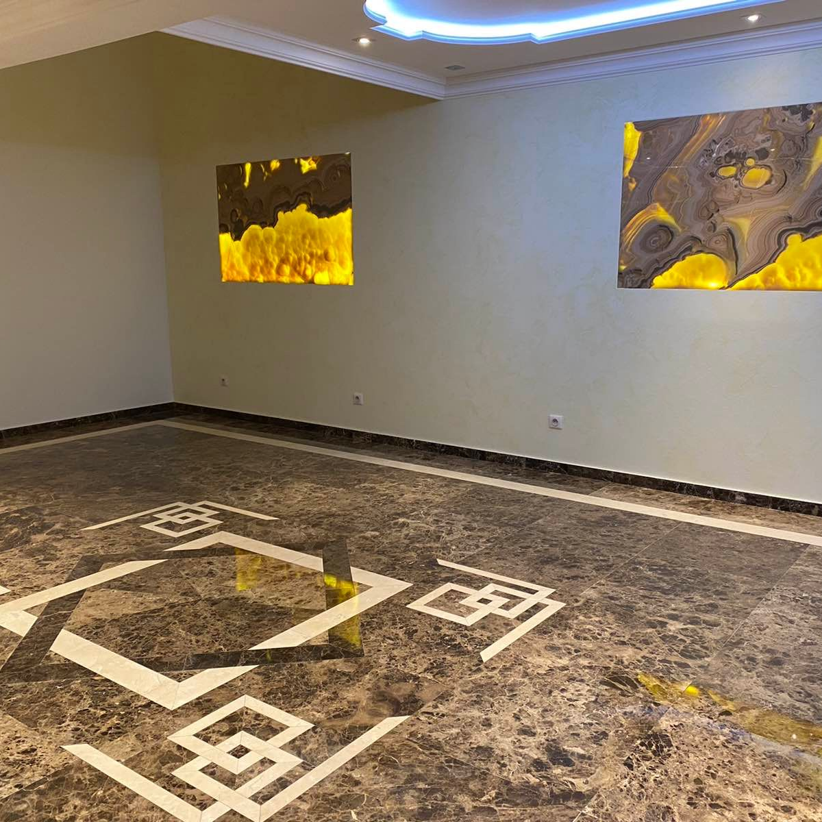 Pièce vide avec sol en marbre et art abstrait au mur.