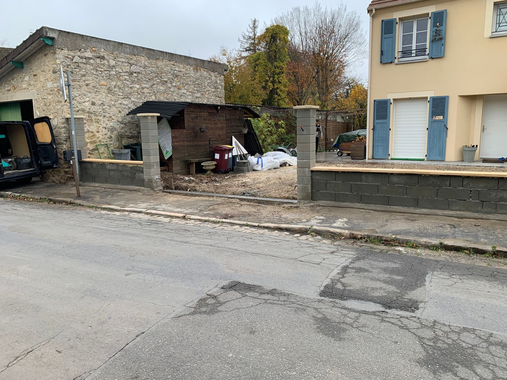 Cheminée extérieure en briques avec ouvertures cintrées et portail décoratif en fer forgé.