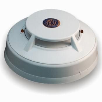 Un detector de humo blanco está colocado sobre una superficie blanca.