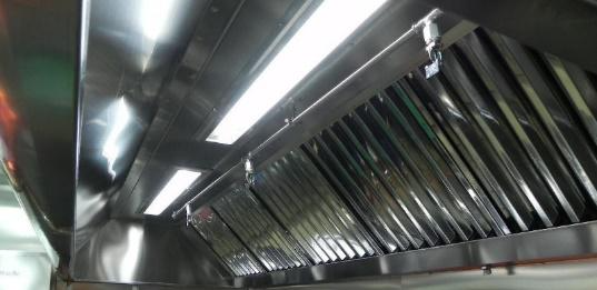 Un primer plano de una campana extractora de acero inoxidable en una cocina.