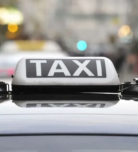 Un primer plano de un cartel de taxi encima de un coche.