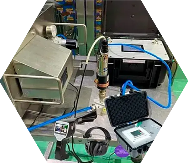 Una máquina está colocada encima de una mesa al lado de un estuche y unos auriculares.