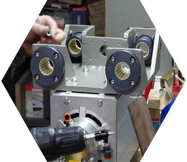 Una persona está trabajando en una máquina con un taladro.