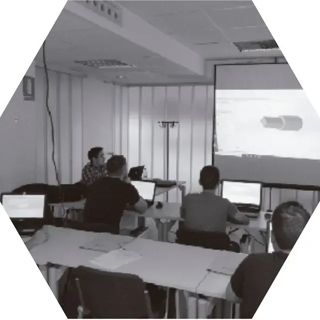 Un grupo de personas está sentado frente a una pantalla de proyector.