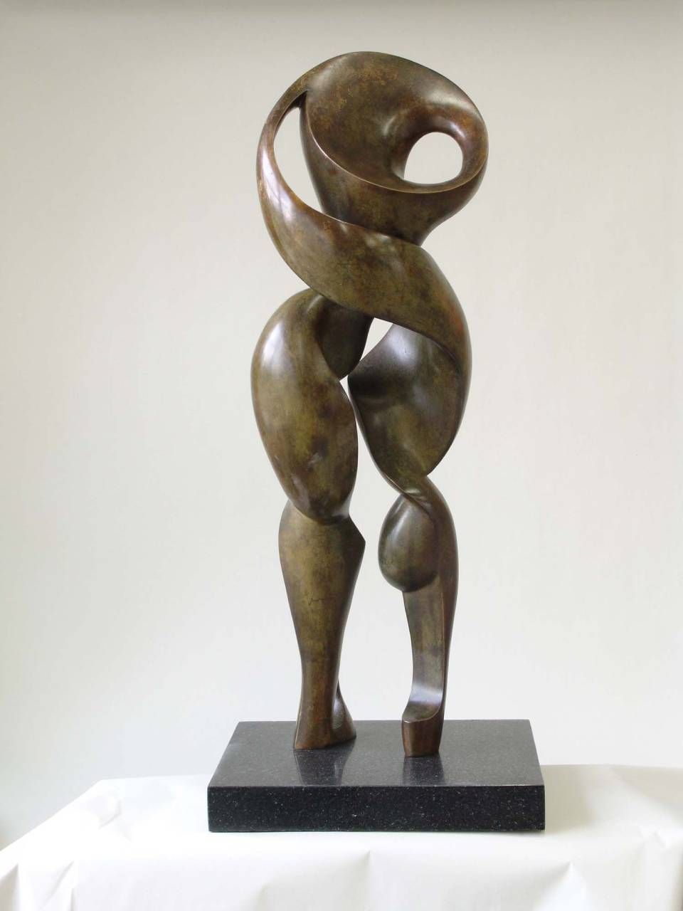Abstrakte Bronzeskulptur einer stilisierten menschlichen Figur, die auf einem schwarzen Sockel steht