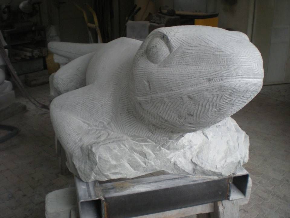 Weisse, skulpturale Tierfigur auf einem Metallständer in einer werkstattähnlichen Umgebung