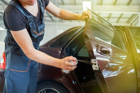 Schwarzes Auto mit Kratzern und Beulen erhält Reparatur Schwarzes Auto mit Kratzern und Beulen erhält Reparatur