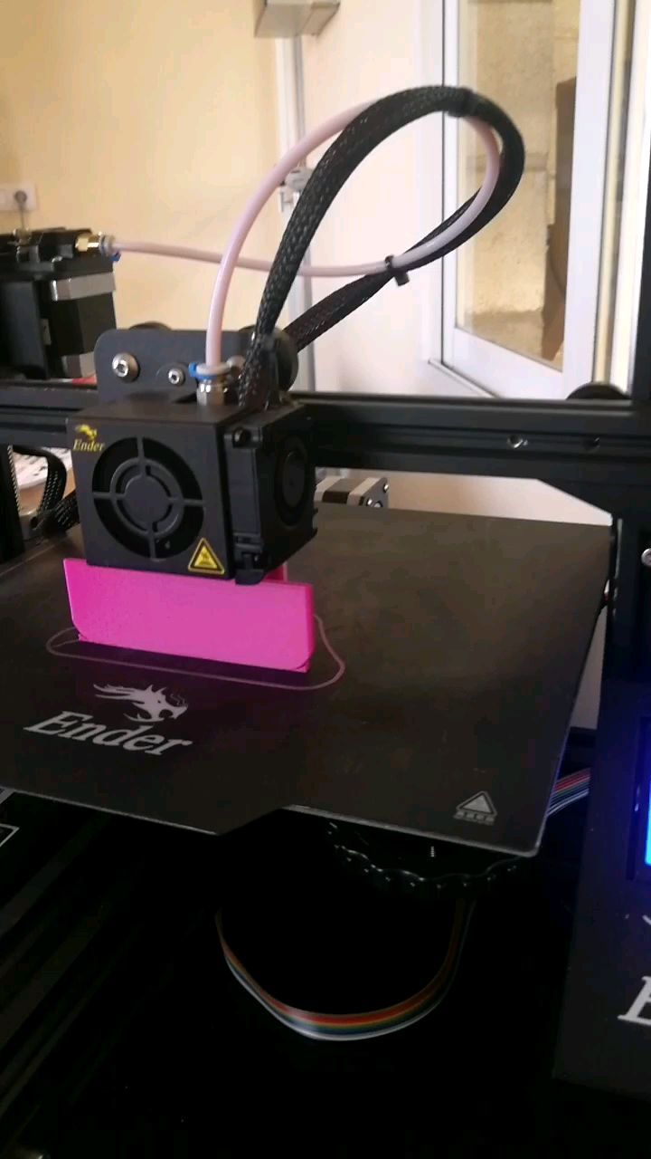Se está imprimiendo un objeto rosa en una impresora 3D.