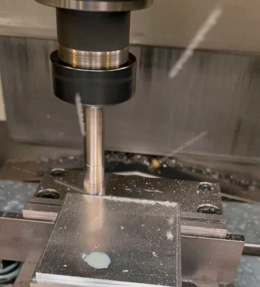 Una máquina está cortando un trozo de metal sobre una mesa.