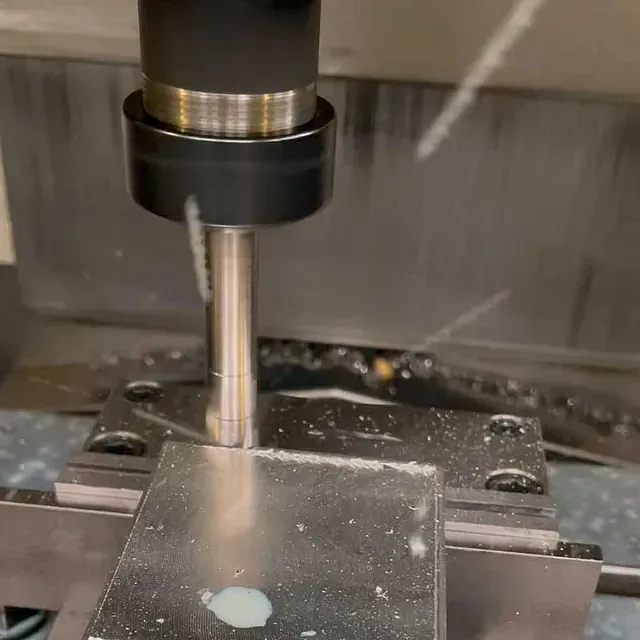 Una máquina está cortando un trozo de metal sobre una mesa.