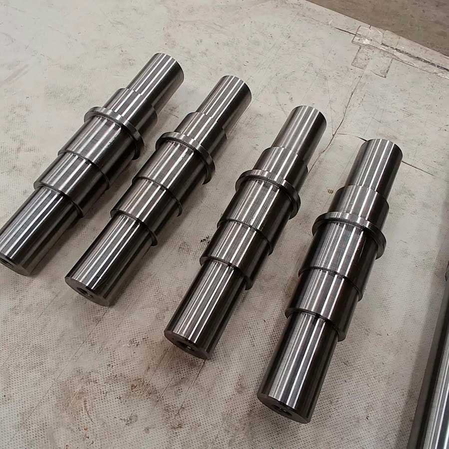 Cuatro piezas de metal están apiladas una encima de otra sobre una mesa.