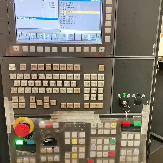 Un panel de control de una máquina tiene un botón rojo de parada de emergencia.