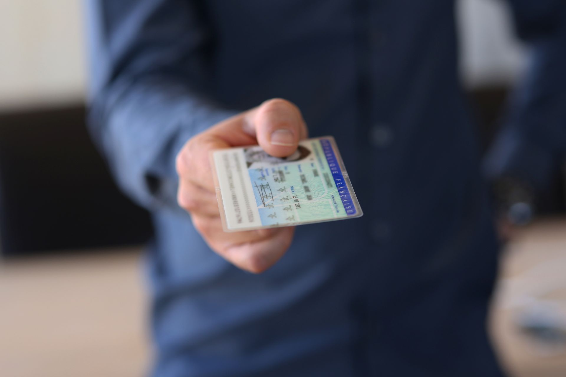 Une personne tend une pièce d'identité