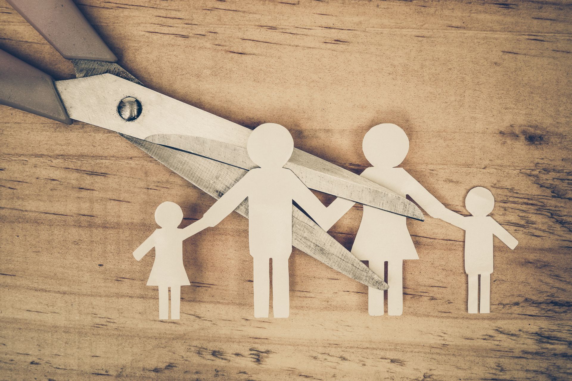 Une paire de ciseaux sur le point de couper une famille en papier