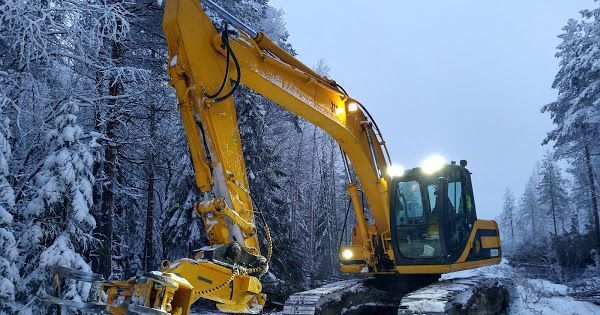 Keltainen kaivinkone talvella